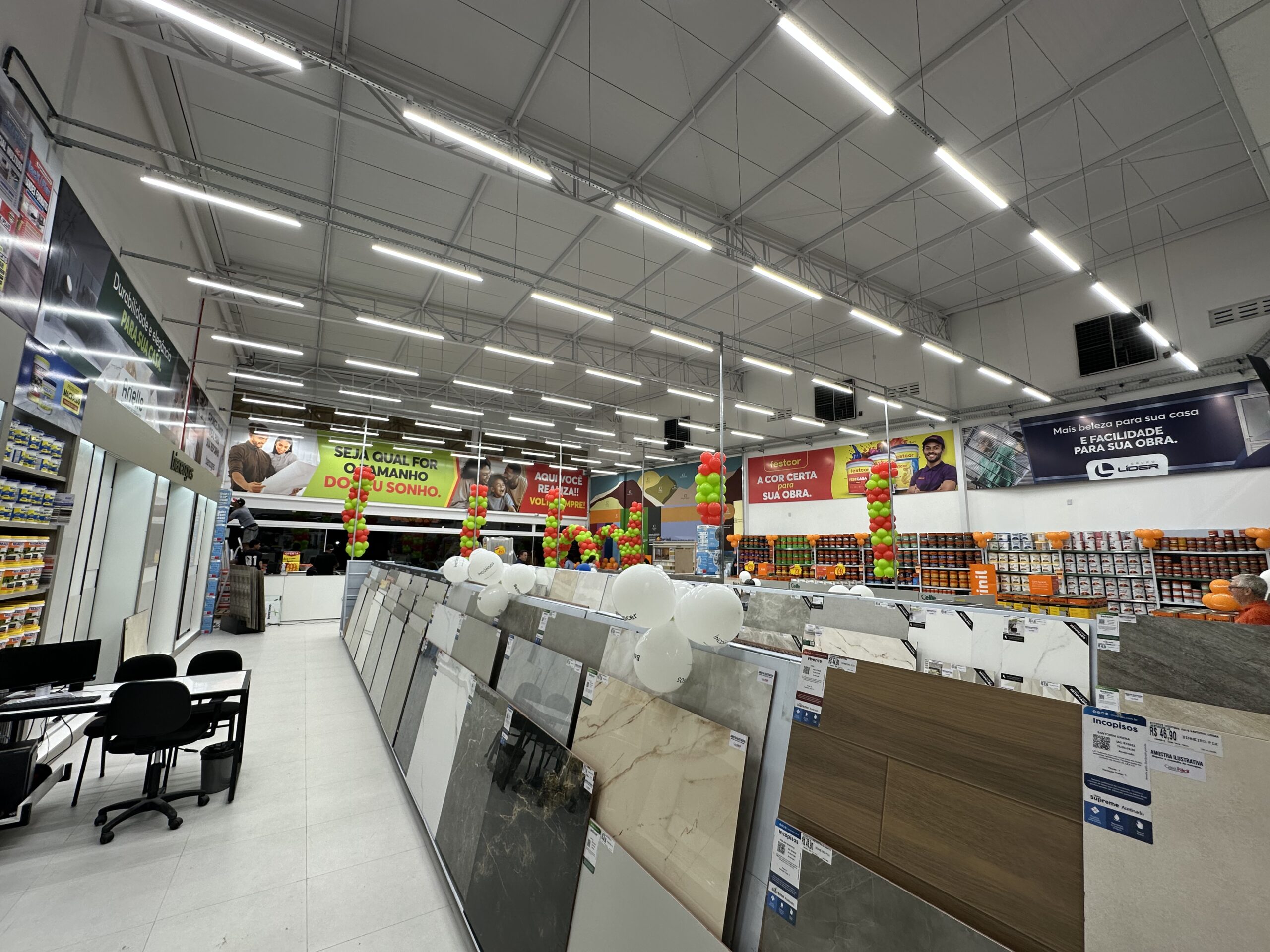 Loja de materiais para construção com iluminação LED uniforme, corredores organizados e produtos bem destacados.