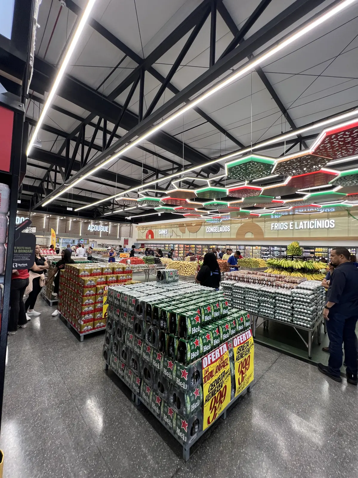 Luminárias lineares no teto e iluminação da área de vendas de um supermercado